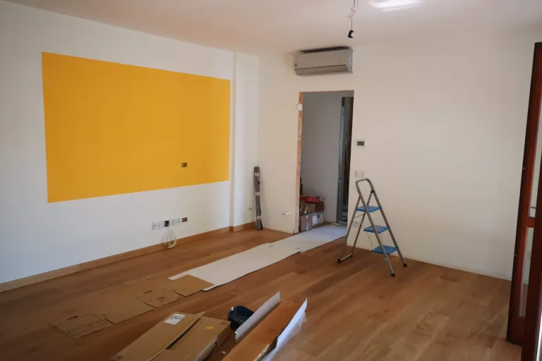 Lichte lege kamer in renovatie met ladder en gereedschap, klaar om de wanden af te werken