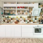 Lichte moderne keuken met witte kasten en een kleurrijke tegelwand als achterwand