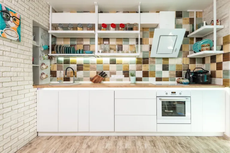 Lichte moderne keuken met witte kasten en een kleurrijke tegelwand als achterwand
