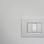 Moderne witte lichtschakelaar op een strakke muur, netjes aangesloten en afgemonteerd