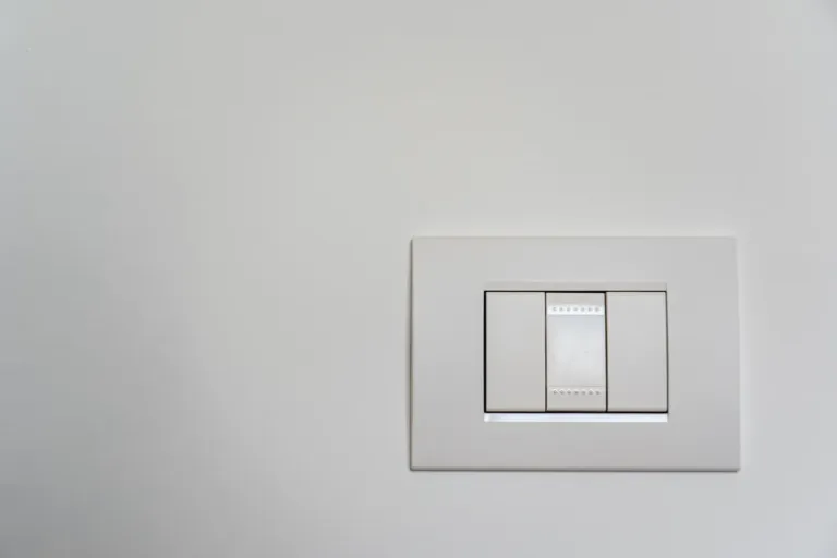Moderne witte lichtschakelaar op een strakke muur, netjes aangesloten en afgemonteerd