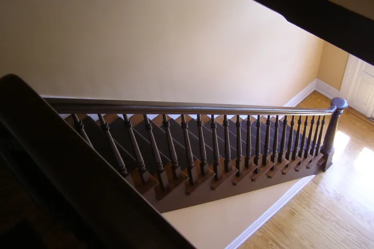 Houten trap met leuning in een woonhuis, voorbeeld van een trap verven of lakken