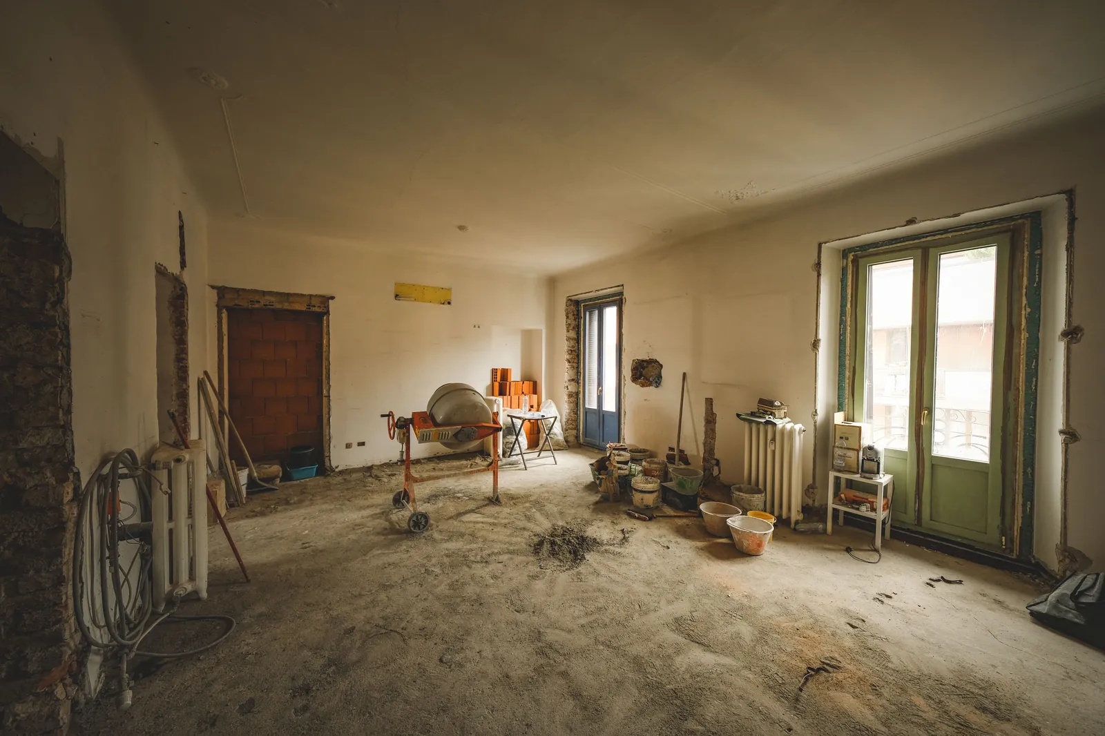 Zonnige kamer in renovatie met bouwmaterialen en gereedschap klaar om de vloer te egaliseren